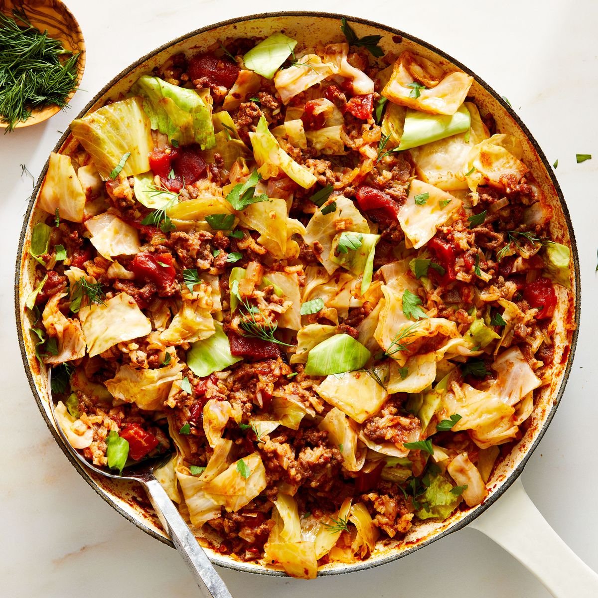 A pan with cabbage and meat in it. 