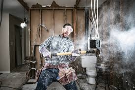 A frustrated contractor swinging a sledgehammer at an electrical outlet
