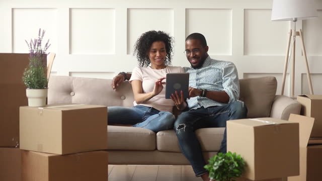 A couple sitting on couch looking at ipad
