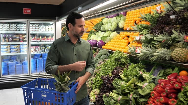 A man at the grocery picking out produce.