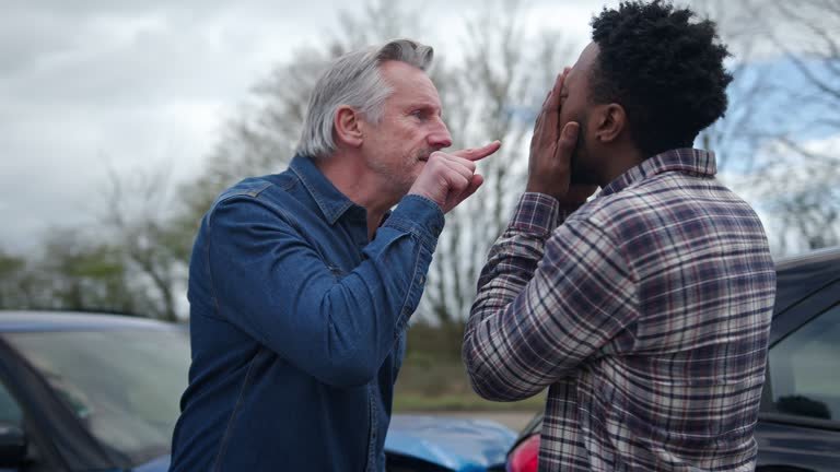 An angry white male yelling, screaming and pointing his finger in a black gentleman's face. 