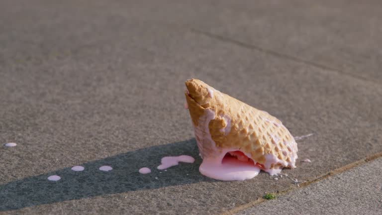 An ice cream cone melting on the ground. 