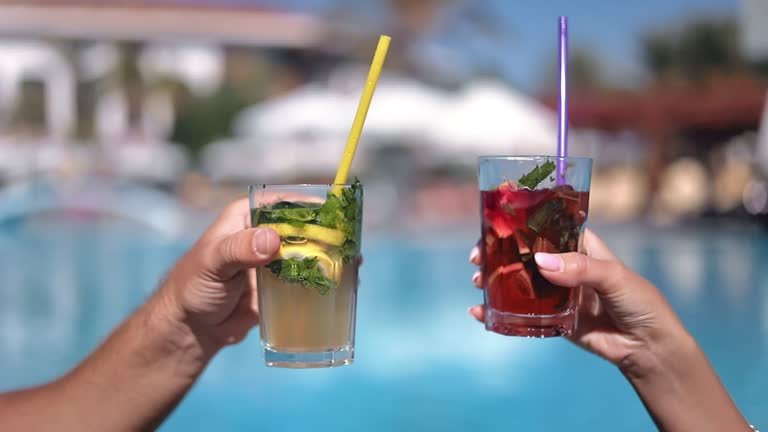 Two people cheering by the pool