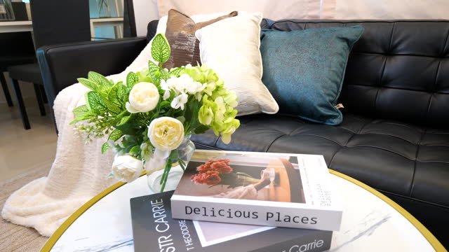 A vase of flowers next to so coffee table books.