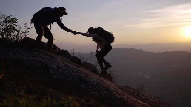 A person helping another person on a trail