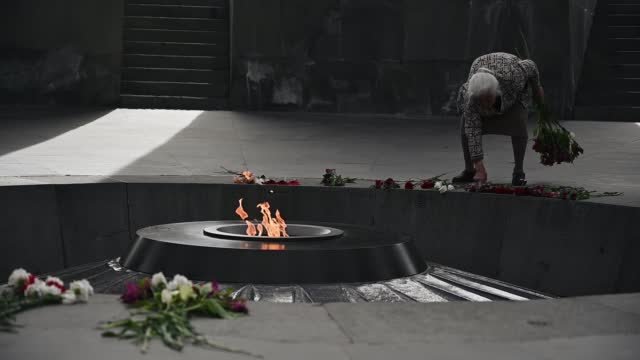 A person placing flowers at an Armenian Genocide memorial. 