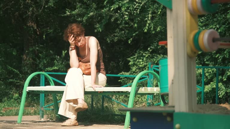A woman sitting on a bench suffering from a heat stroke 