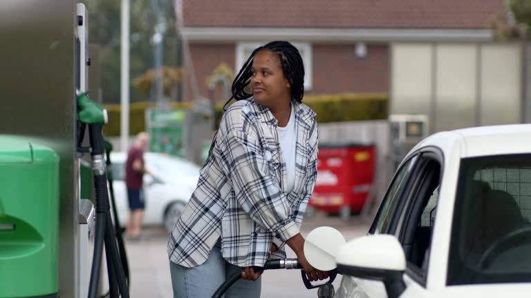 A black lady pumping her gas at a gas station