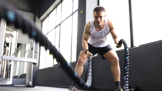 A white male working out with a rope.