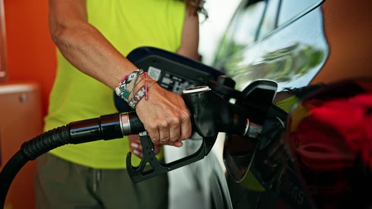 A guy pumping gas at a gas station