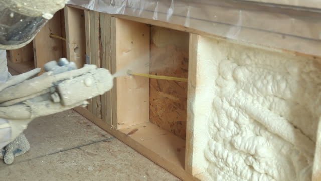 A man installing insulation