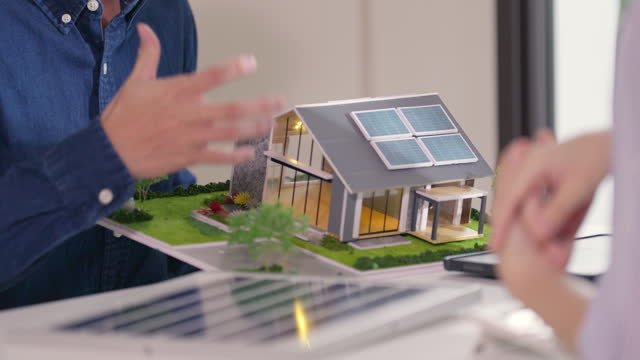 A miniature house with solar panels on it. 