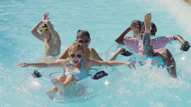 A group of young children playing on tubes in the water