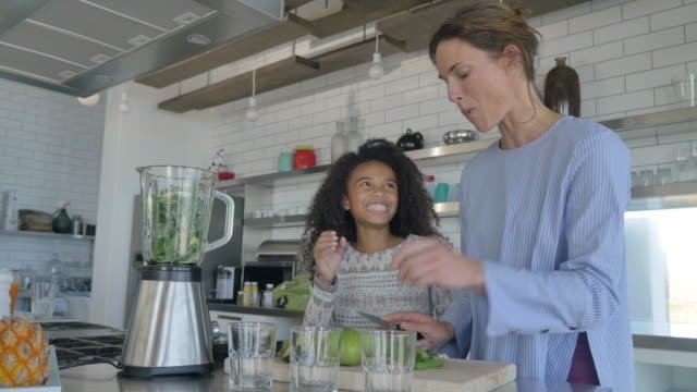 A mother and daughter making a green smoothie